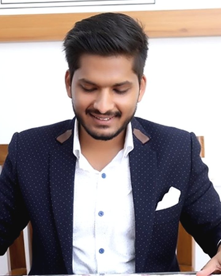 Lakshya Rai Aggarwal in a navy jacket, looking down at the desk in front of him