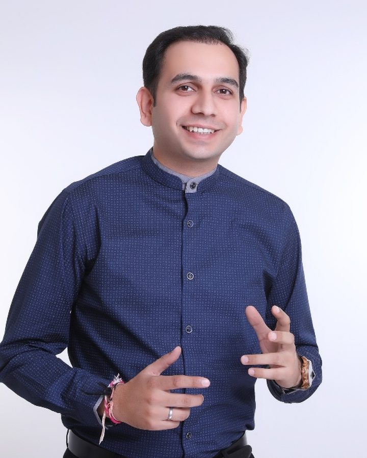 Dr. Sachin Atray, in a deep-blue shirt, mid-conversation