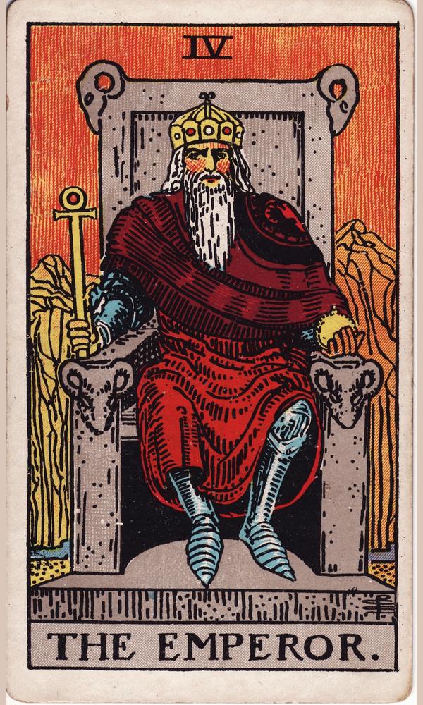 The Emperor — a crowned ruler in red on a stone throne carved with rams’ heads, holding an ankh sceptre
